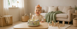 aby feiert ersten Geburtstag am Tisch mit Kuchen und Kerze, Geschenke zum ersten Geburtstag