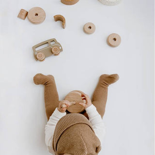 Baby greift Holzspielzeug — geeignet ab 6 Monaten, erstes Lebensjahr
