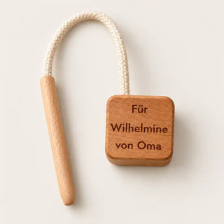 KAWI Senso Holzteil mit persönlicher Lasergravur Für Wilhelmine von Oma daneben die Baumwollkordel mit Fädelstift